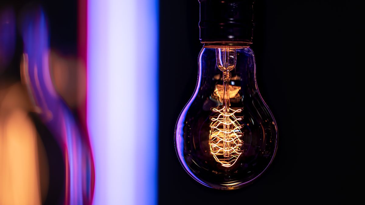 Una bombilla encendida con reflejos morados