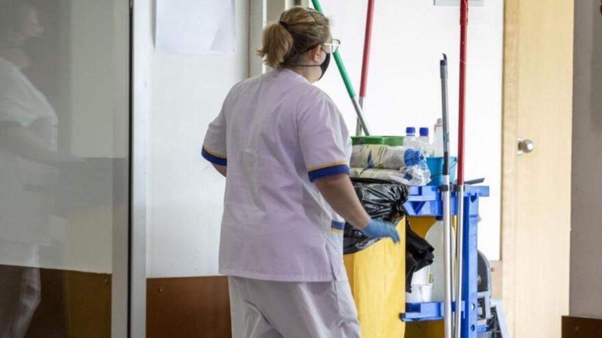 Una trabajadora de la limpieza arrastra un carrito