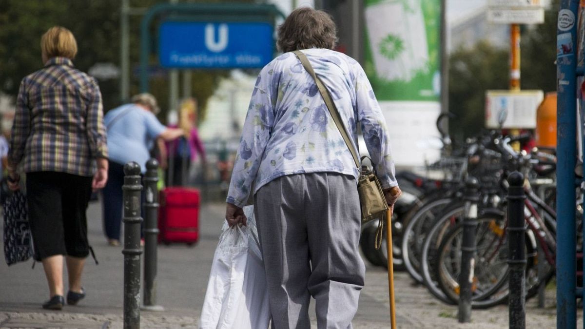 Una jubilada alemana camina por una calle comercial en Berlín