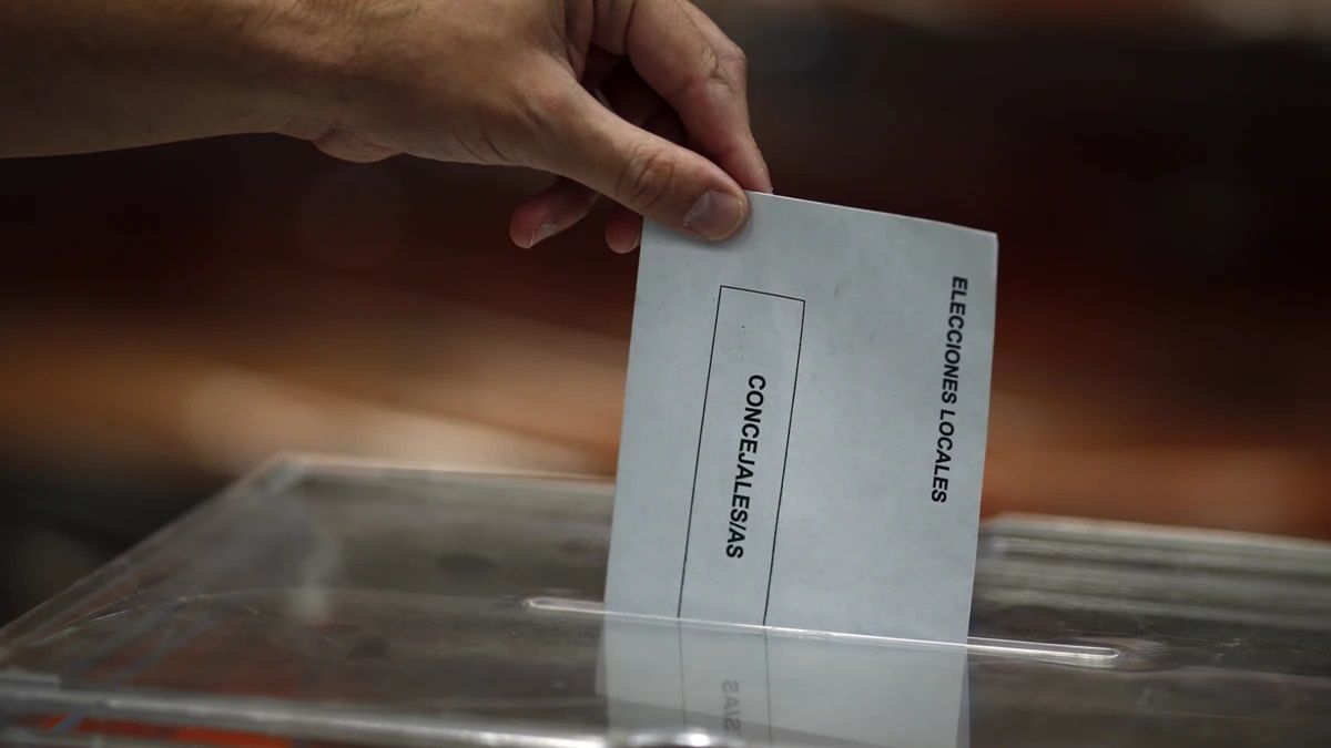 Una persona depositando el voto en una urna.