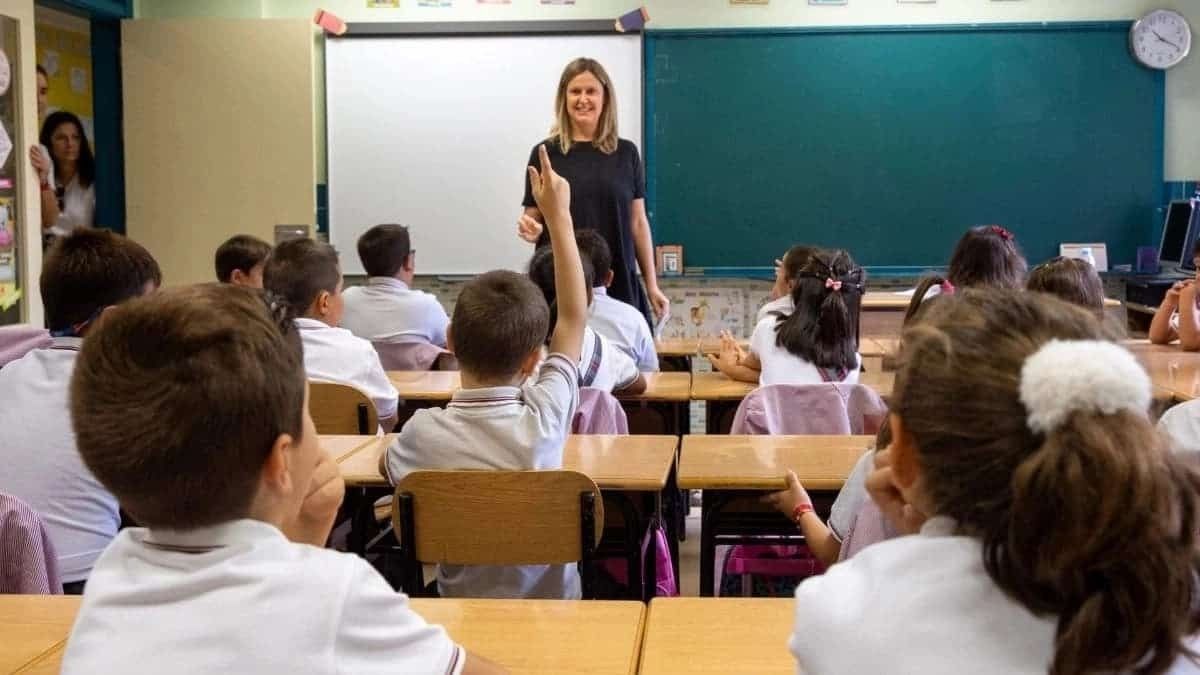 Una maestra impartiendo clase en un colegio con niños