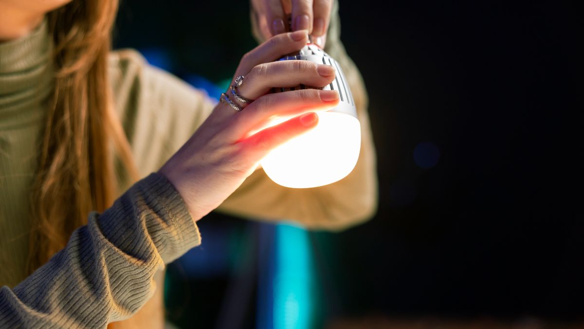 Una mujer sujetando una bombilla encendida
