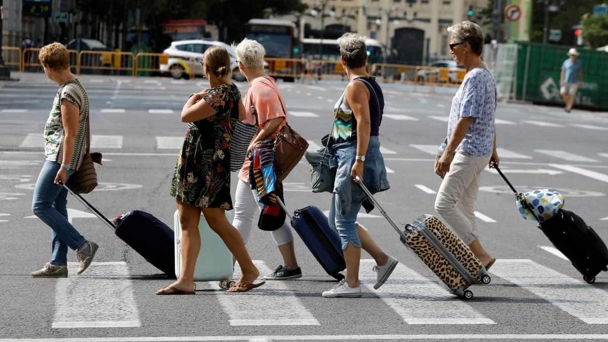Un grupo de jubilados cruza la calle con maletas