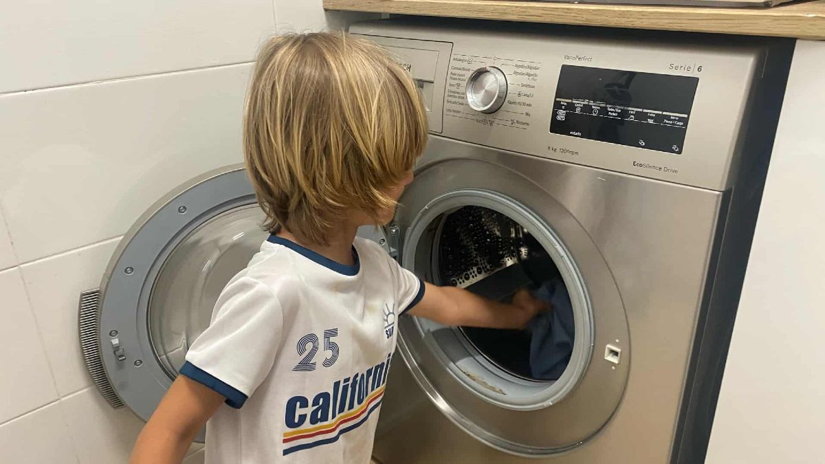 Niño pone la lavadora en casa