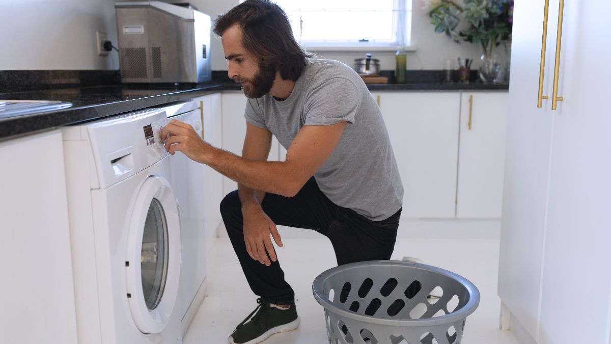 un hombre poniendo una lavadora