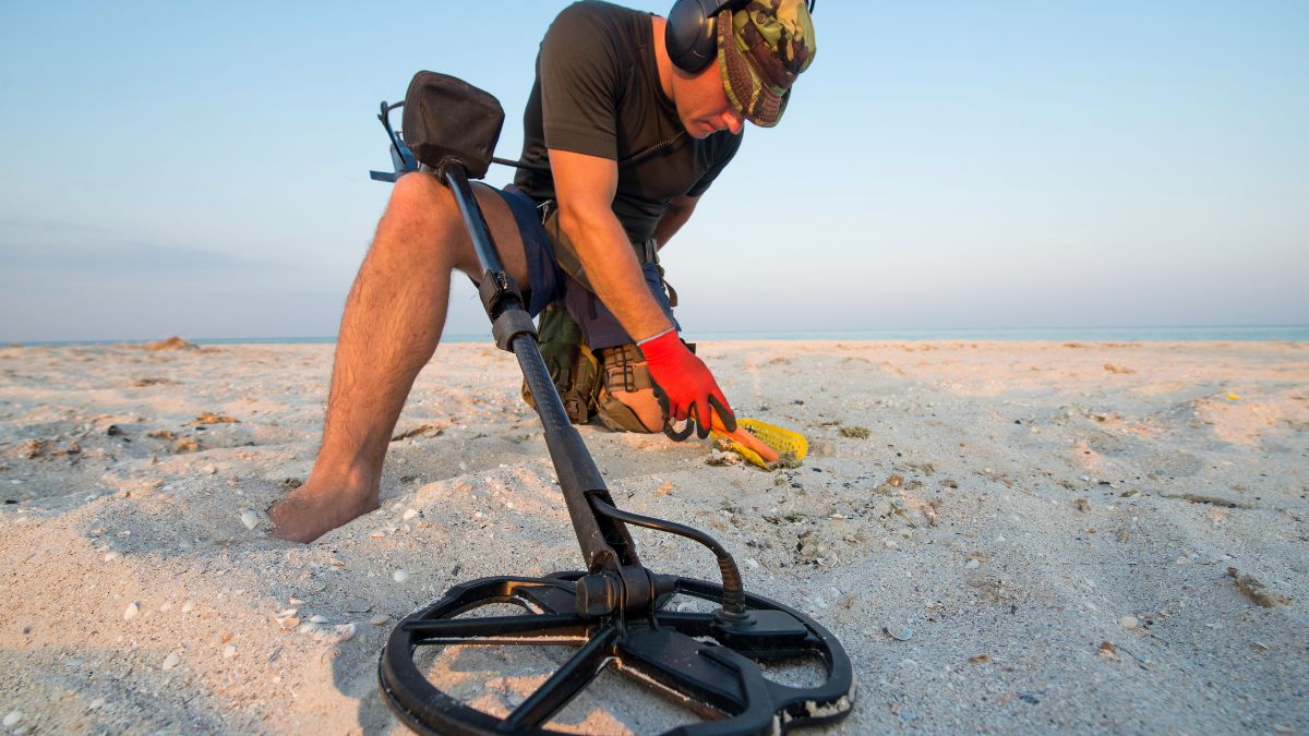 Un hombre con un detector de metales en la playa