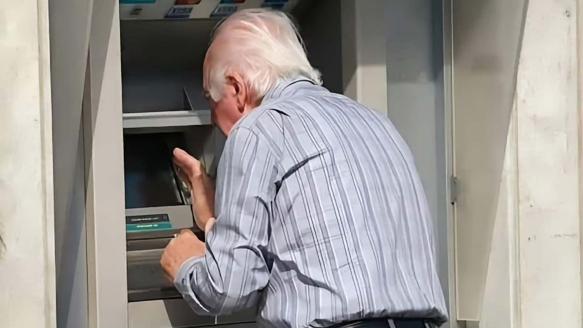 Un anciano saca dinero del cajero