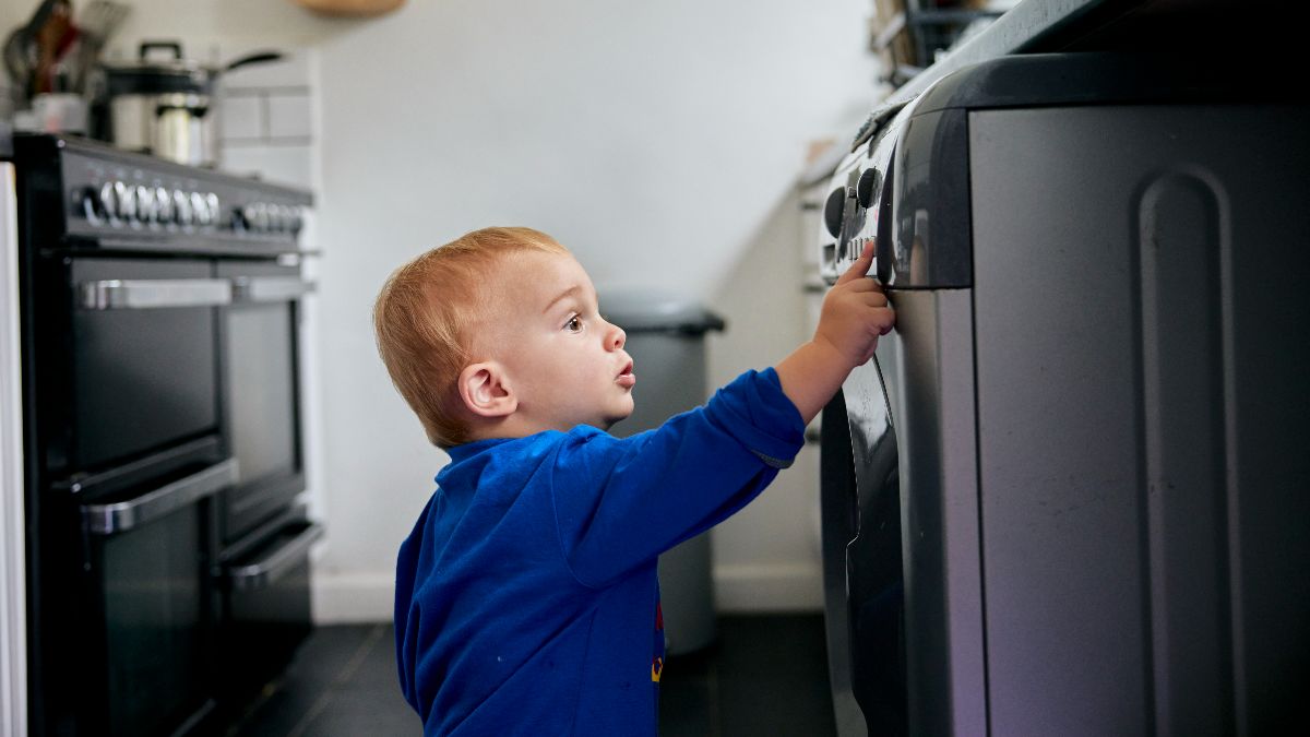 Un niño pequeño tocando los botones de la lavadora