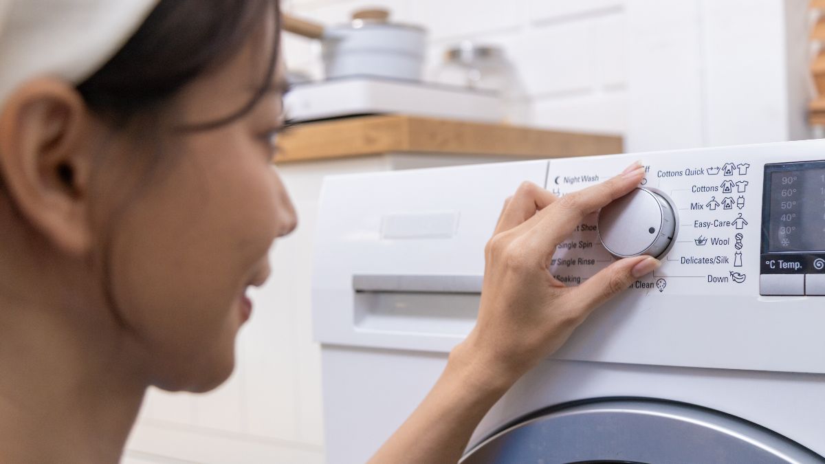 una mujer encendiendo la lavadora