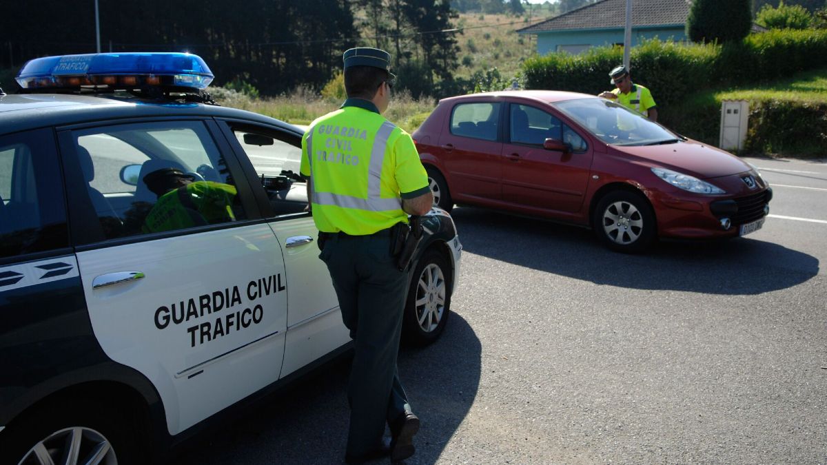 Unos agentes de la Guardia civil revisando la guantera de un coche