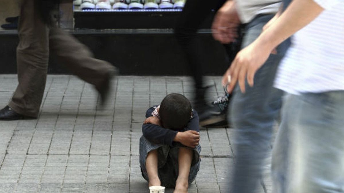 Un niño pide limosna en una calle