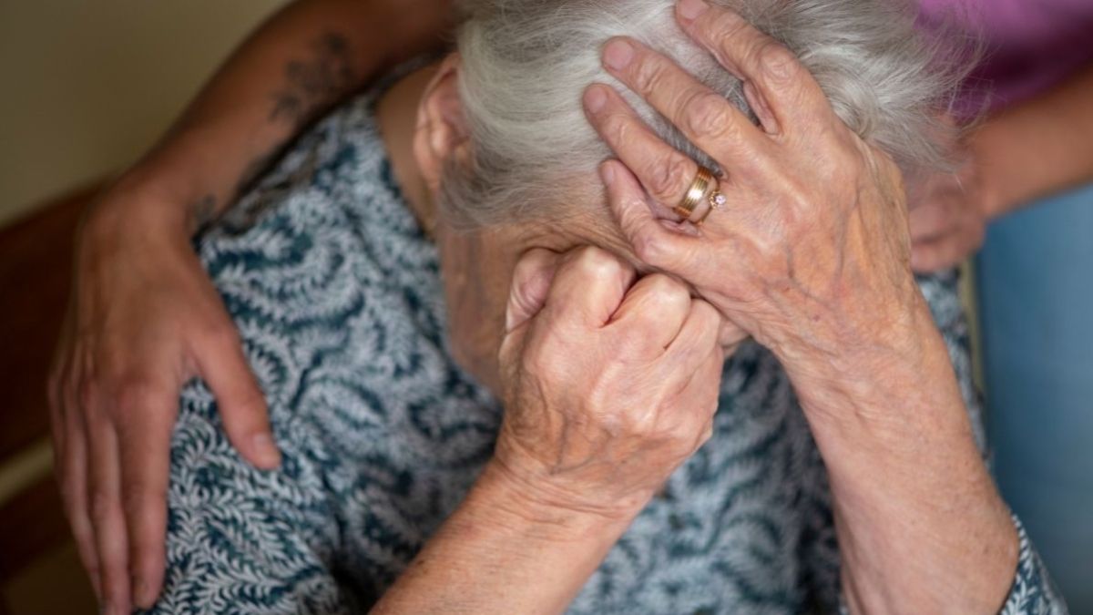 Una mujer mayor llorando mientras alguien la abraza