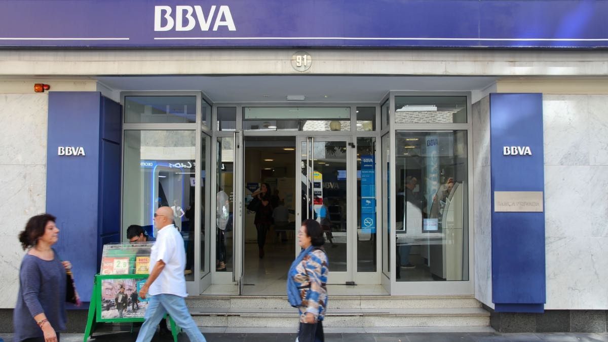 Gente pasando delante de un banco BBVA