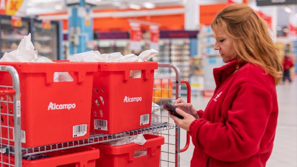 Una trabajadora de Alcampo junto a varias cajas