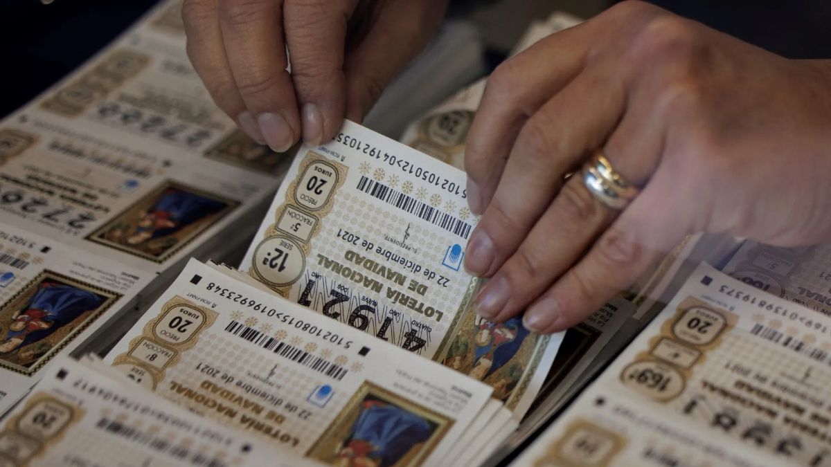 Una mujer escogiendo un décimo de Lotería de Navidad