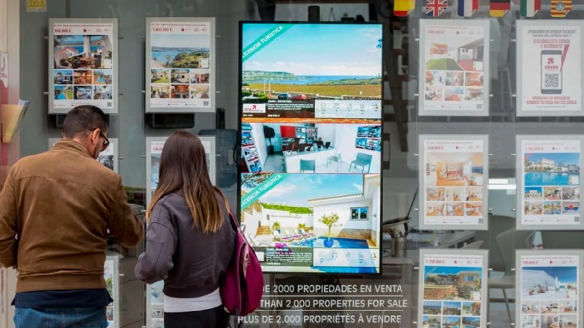 Dos jóvenes mirando carteles en una inmobiliaria