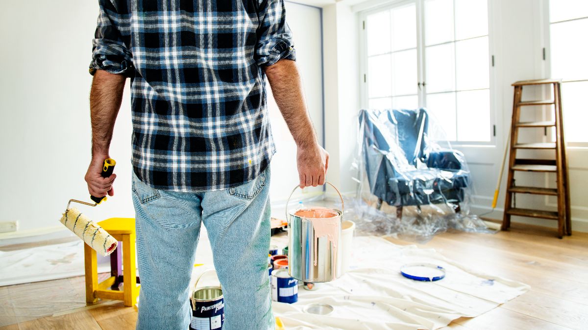 Un hombre pintando el salón de una casa