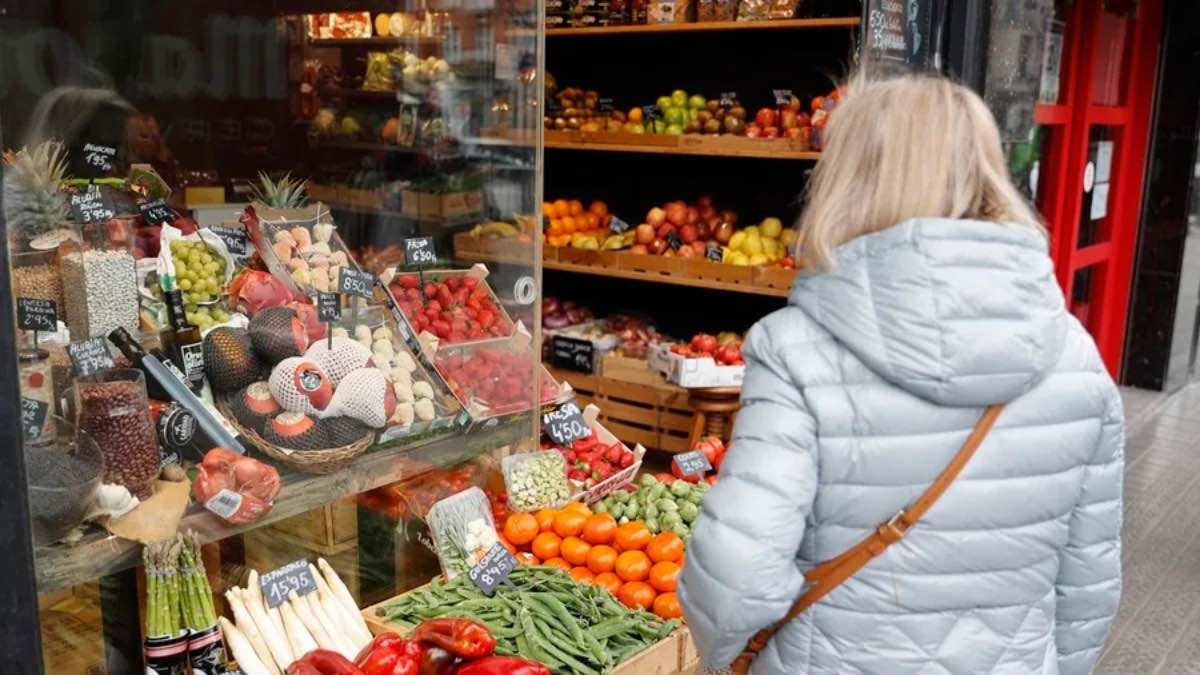Una mujer observando los precios de una frutería