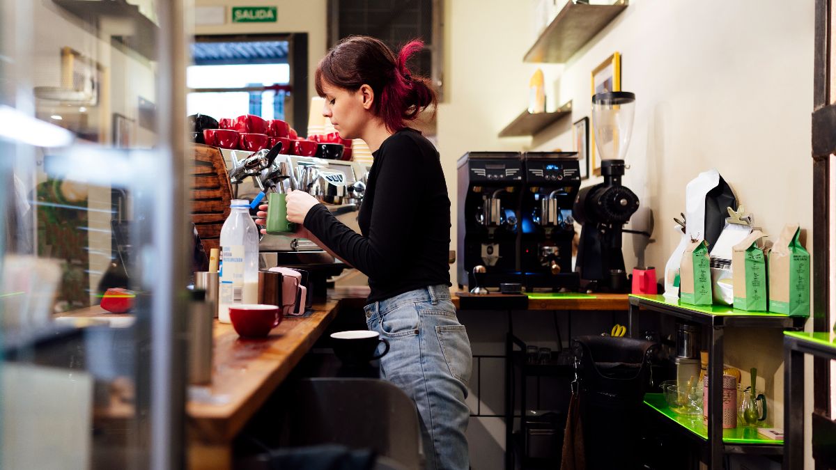 Una camarera haciendo un café