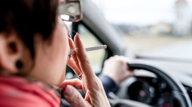 Una mujer fumando en el coche 