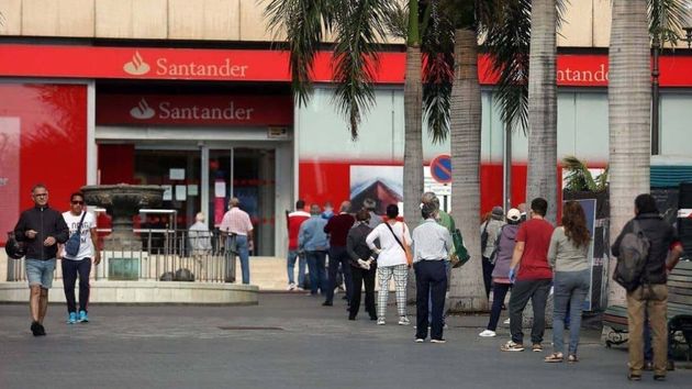 un banco santander con mucha gente llegando