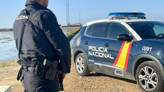 un agente y un coche de la policía nacional