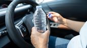 Una persona con una botella de agua abierta al volante