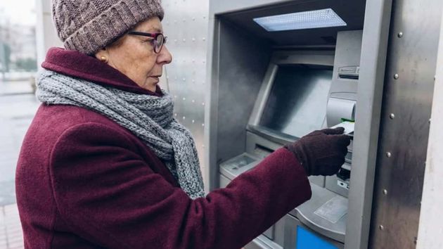 Pensionista saca dinero de su pensión de un cajero