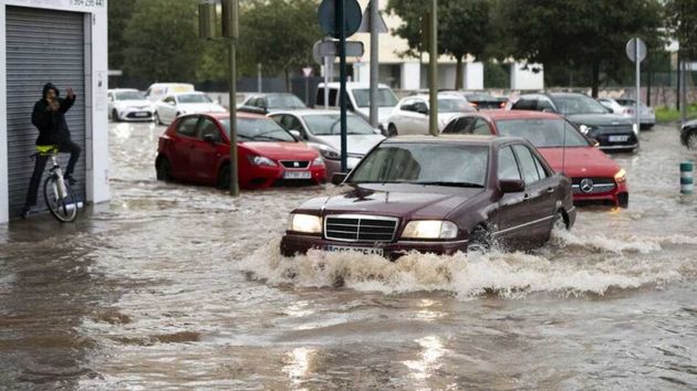 unos coches en una calle inundada