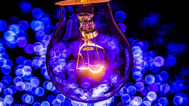 Bombilla de luz encendida con destellos azules