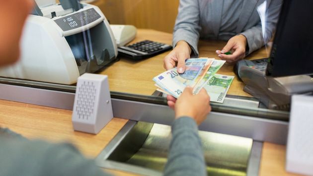 Una persona sacando dinero del banco 