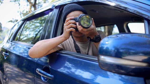 un espía haciendo fotos desde el coche