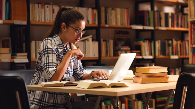 Joven estudiando en una biblioteca
