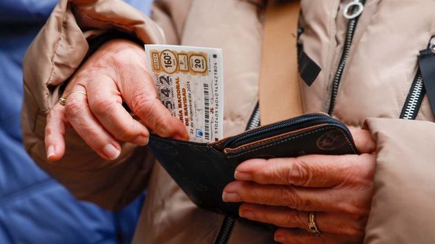 Una mujer guardando un décimo de Lotería de Navidad