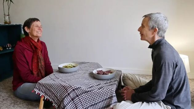 La pareja sentada en el suelo junto a una mesa 