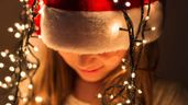 joven con gorro y luces de Navidad sobre la cabeza