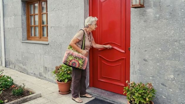 Una mujer abriendo la puerta de una casa