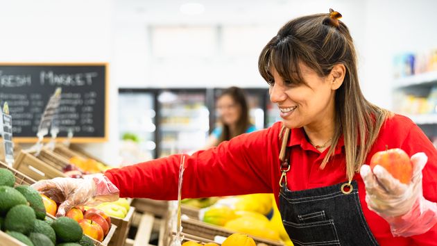 Dependienta colocando fruta
