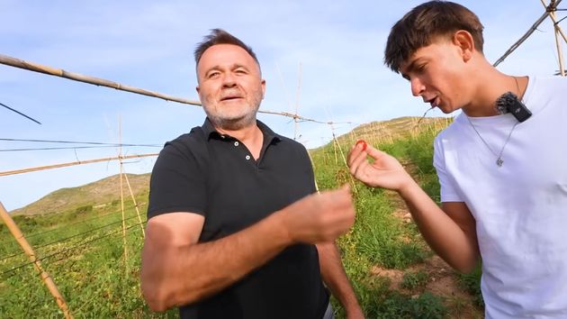 El agricultor con el entrevistador comiendo un tomate en su finca