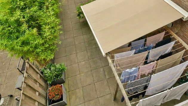 El patio de una vivienda con un toldo y un tendedero