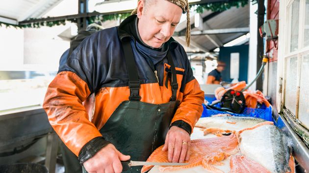 jubilado trabajando cortando pescado