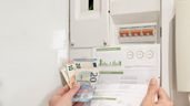 Billetes de euros y factura de luz junto un contador