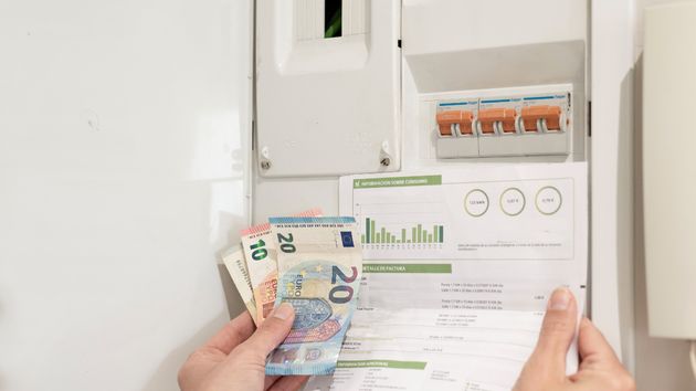 Billetes de euros y factura de luz junto un contador