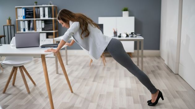 mujer flexiones escritorio oficina