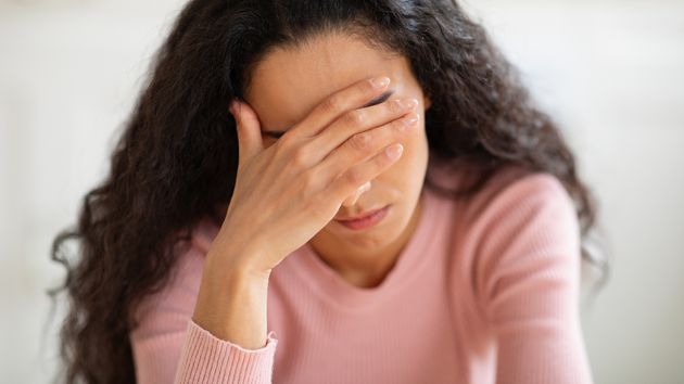 Mujer triste echándose la mano a la cabeza