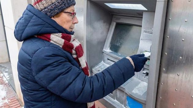 Mujer mayor mayor sacando dinero de un cajero automático