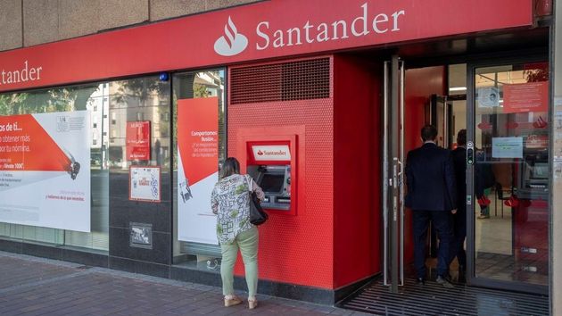 la fachada de un banco santander y una mujer sacando dinero