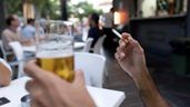 Una persona fumando en una terraza de un bar