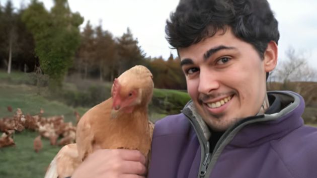 El joven junto a una de las gallinas ponedoras. 