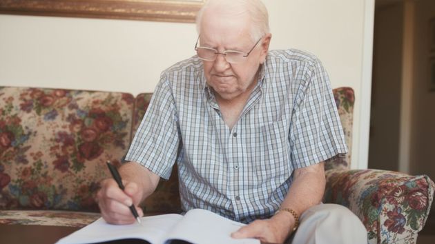 Un anciano firmando un documento